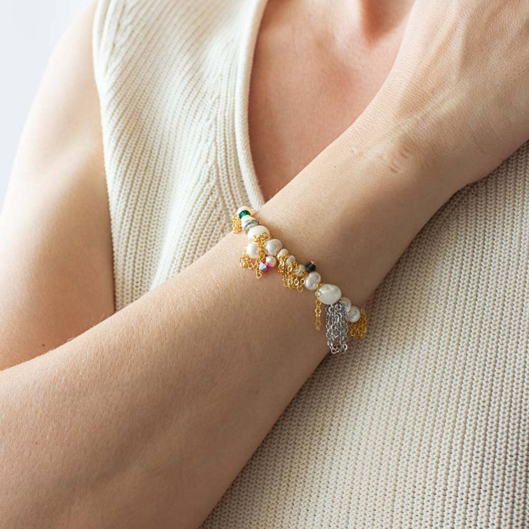 Femme portant un Bracelet Tiffa par Anne-Marie Chagnon doré avec chaînes argentée, perles , billes roses et turquoises