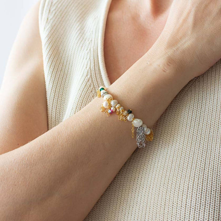 Femme portant un Bracelet Tiffa par Anne-Marie Chagnon doré avec chaînes argentée, perles , billes roses et turquoises