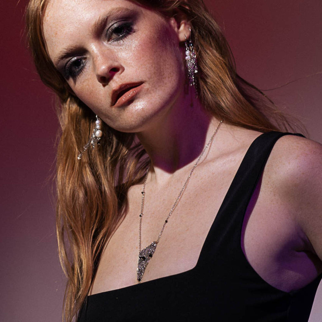 Femme portant un Collier Gania par Anne-Marie Chagnon argenté avec barres en étain comme pendentif, chaînes et billes noires