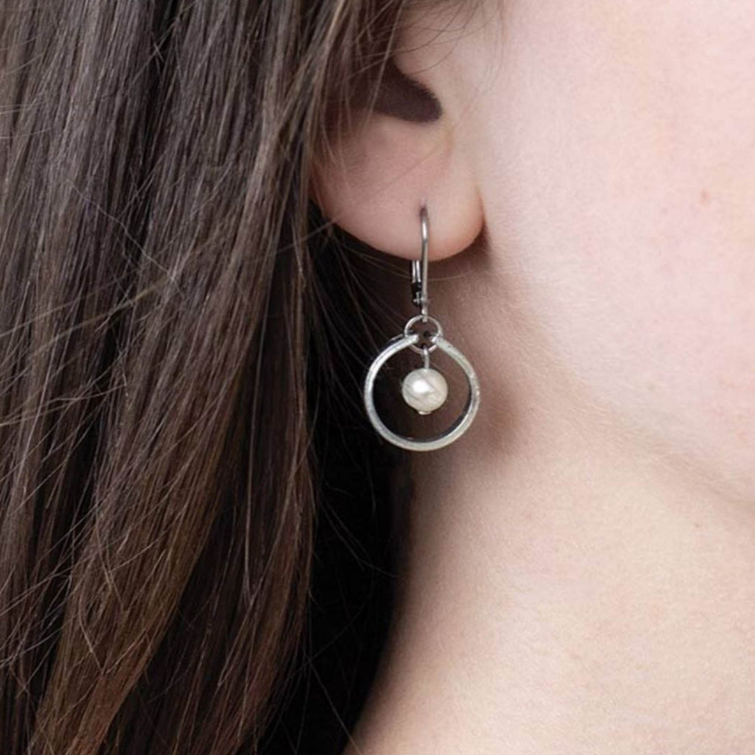 boucles d'oreilles avec attache en charnière cercle couleur étaitn avec petite perle au centre sur l'oreille d'un mannequin