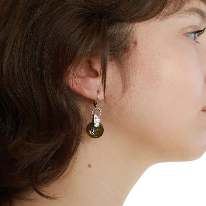 Femme portant une Boucle d'oreilles Dalim avec disque en verre forêt par ANne-Marie Chagnon