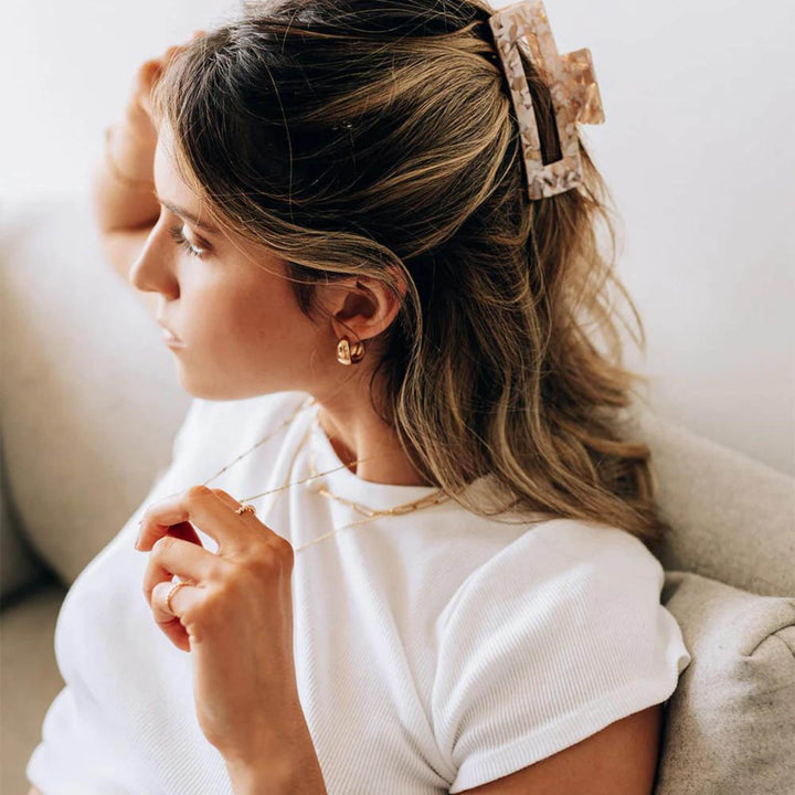 Femme de profil portant des Boucles d'oreilles simple en demi-anneau doré par welldunn