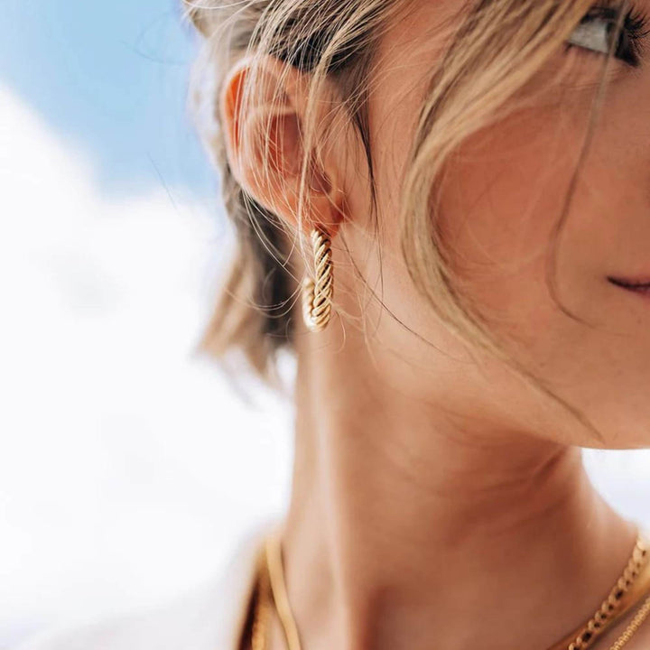 Femme portant une Boucle d'oreille torsadée dorée par welldunn vue de 3/4