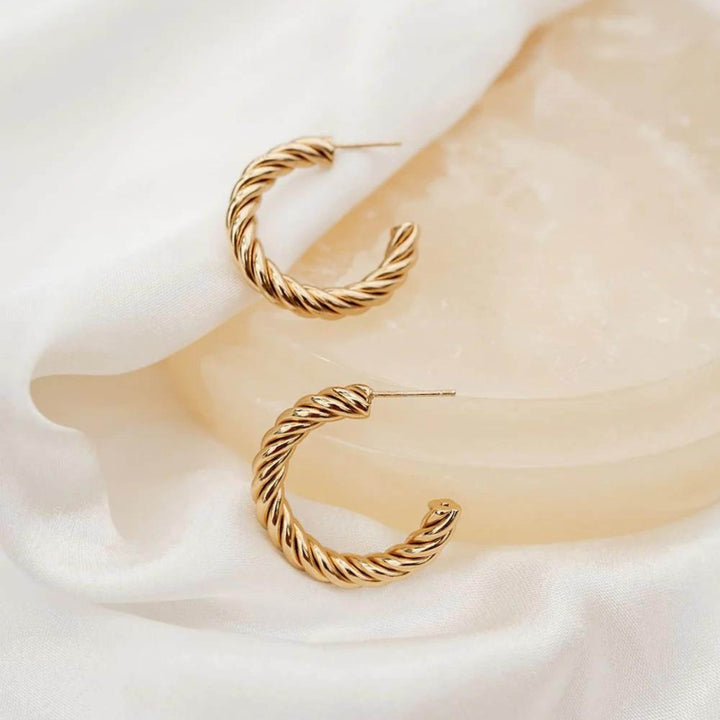 Boucles d'oreilles torsadées dorées par welldunn une sur l'autre