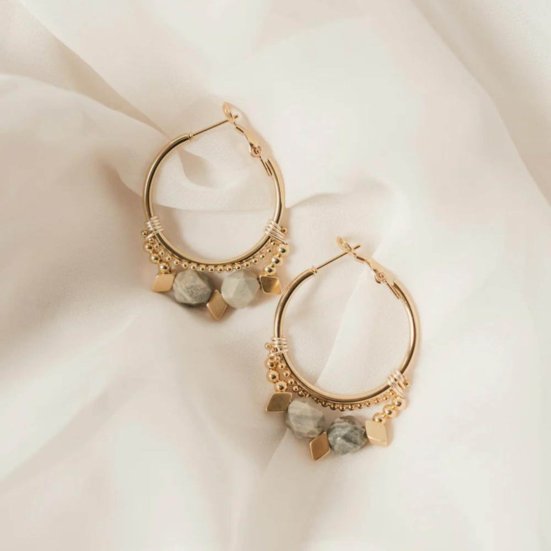 Boucles d'oreilles Zenith par welldun dorées avec pierres suspendues grises et oranges déposées sur du tissus