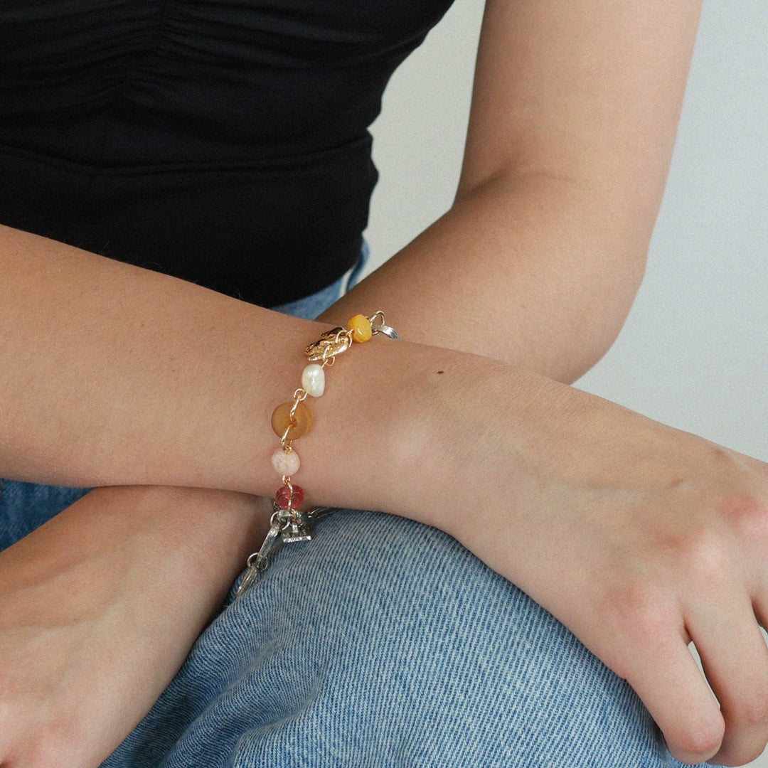 Poignet avec un Bracelet Elnath avec billes jaunes et roses par Anne-Marie Chagnon