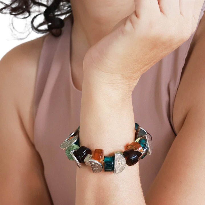 Poignet de femme avec un Bracelet Mankar fait de morceaux de verre bruns, transparents et verts