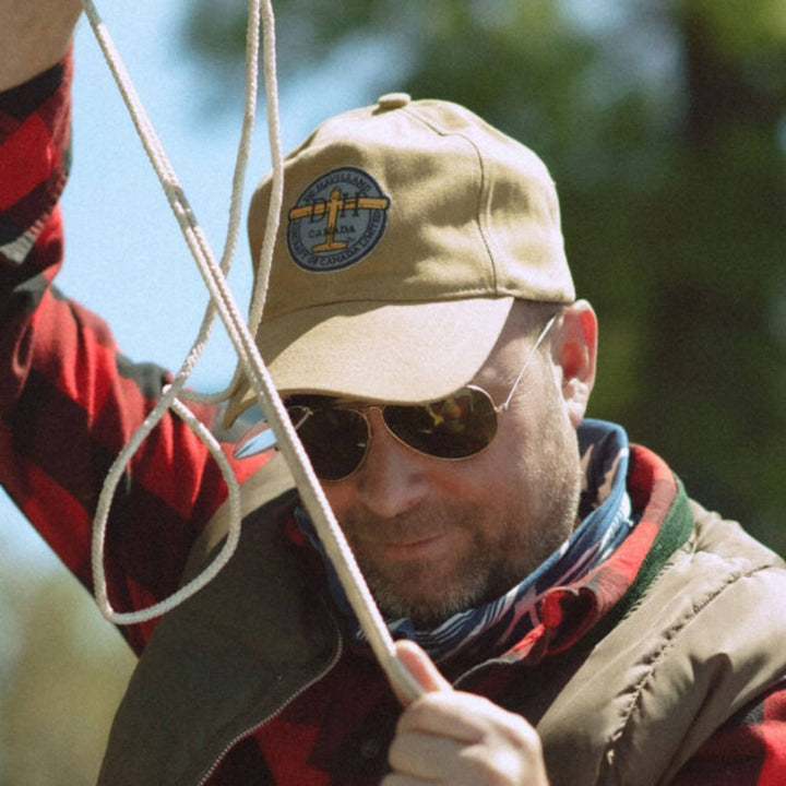 Homme portant une Casquette tan De Havilland avec logo par Red Canoe avec des cordes