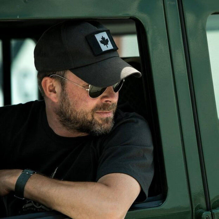 Homme portant une Casquette grise avec drapeau du Canada charbon dans son camion