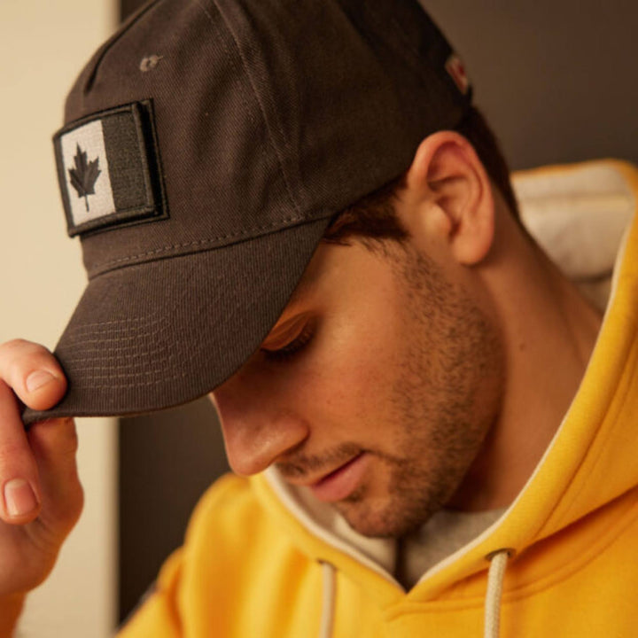 Homme portant une Casquette grise avec drapeau du Canada charbon en penchant la tête