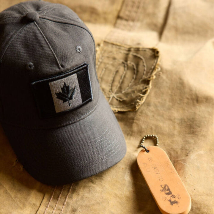 Casquette grise avec drapeau du Canada charbon par Red Canoe à côté d'un porte-clefs