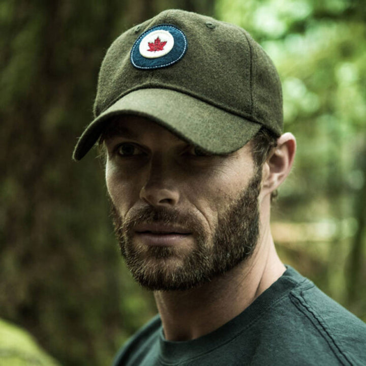 Homme dans la forêt portant une Casquette RCAF en laine kaki avec logo  par Red Canoe
