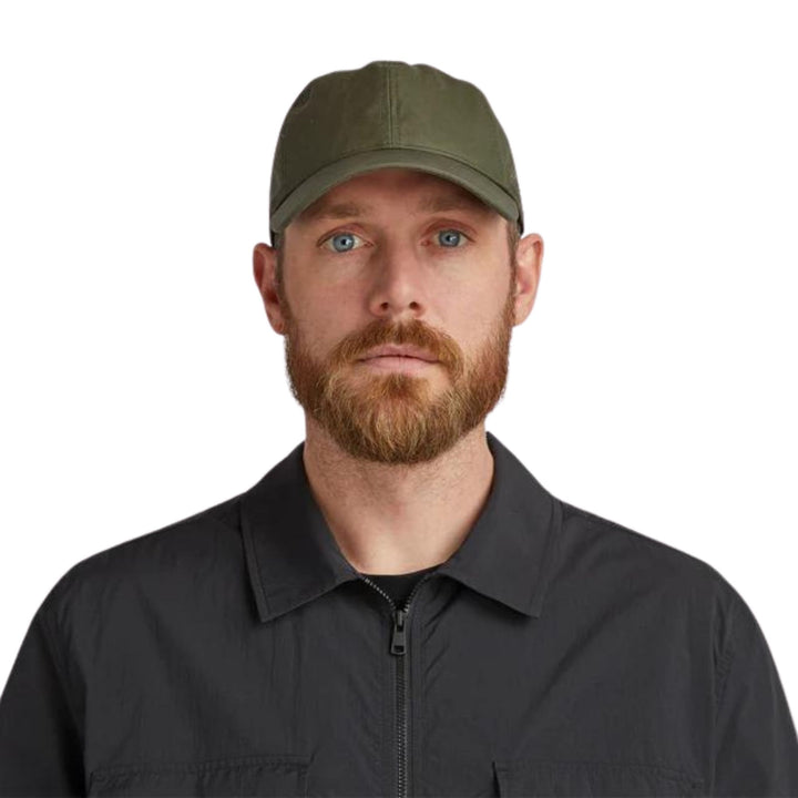 Homme portant une Casquette verte en coton ciré vu de face par tilley