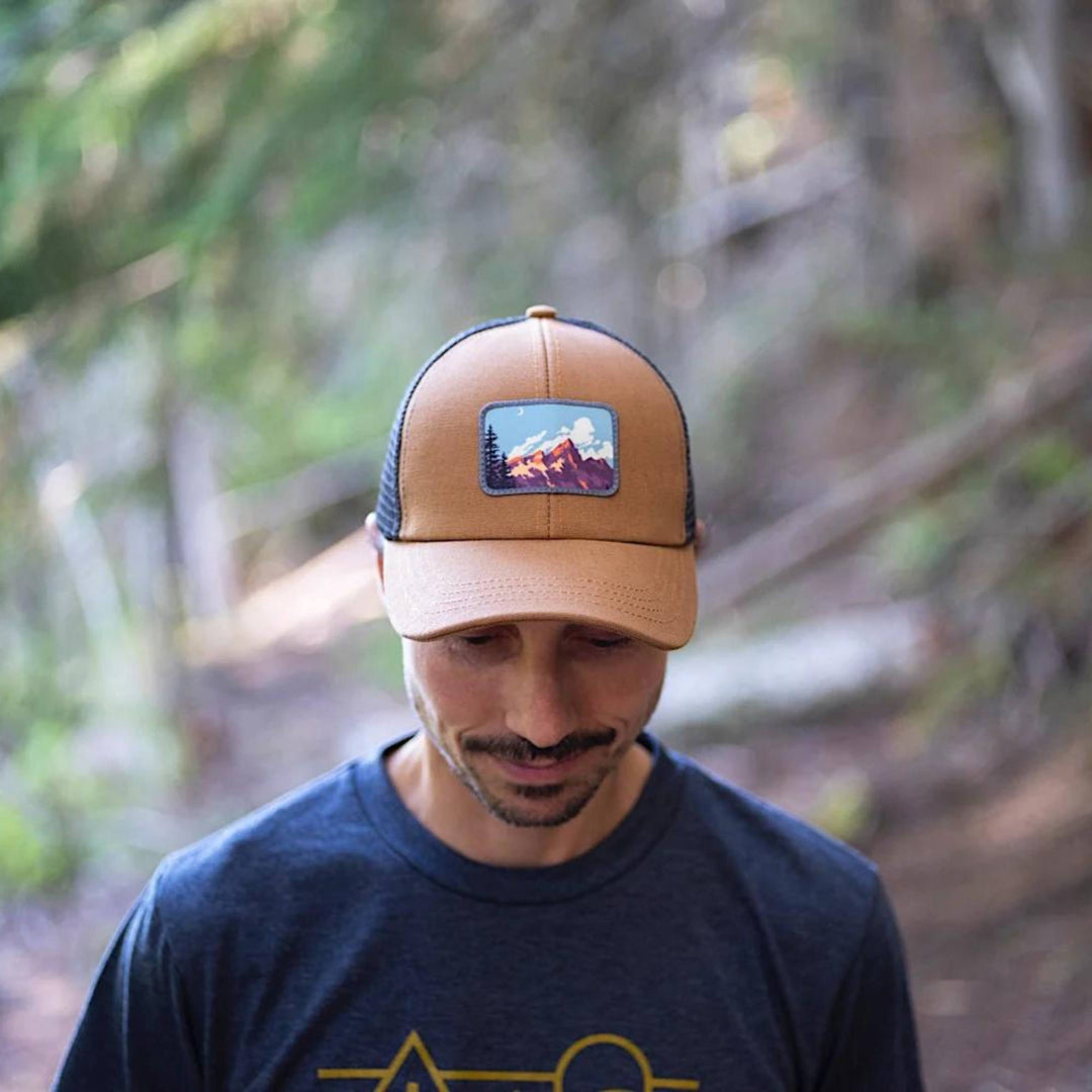 Homme portant une Casquette marron Ambler avec filet noir et motif de paysage sur le devant