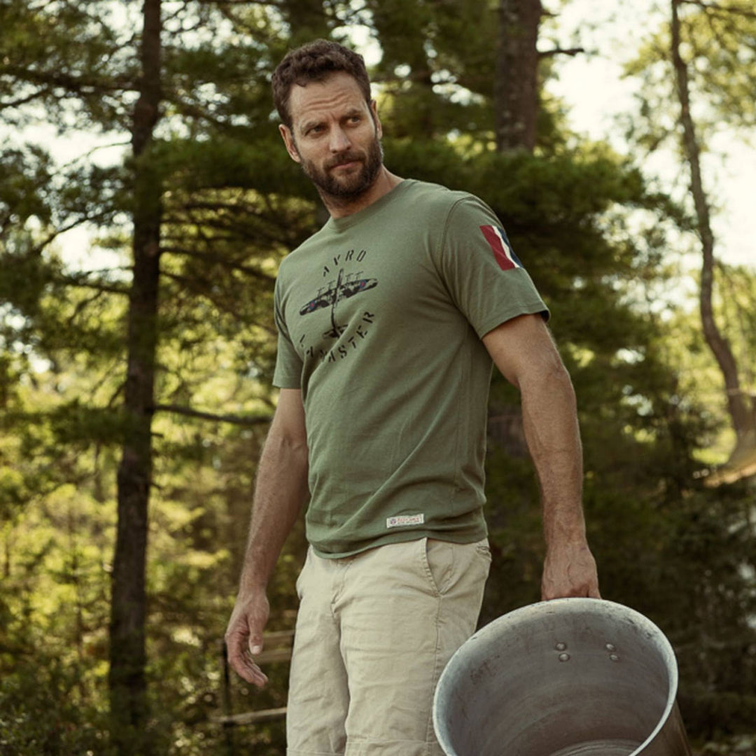 Homme dehors portant un T-shirt vert kaki Avro avec un imprimé d'avion par Red Canoe