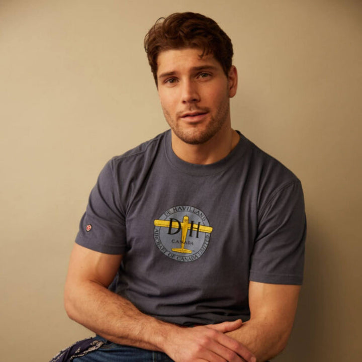 Homme portant un T-shirt de Havilland bleu pour homme par Red Canoe les bras croisés