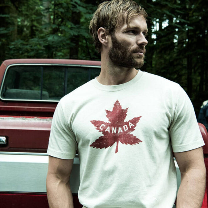 Homme portant un T-shirt heritage canadiens blanc par Red Canoe devant un camion rouge