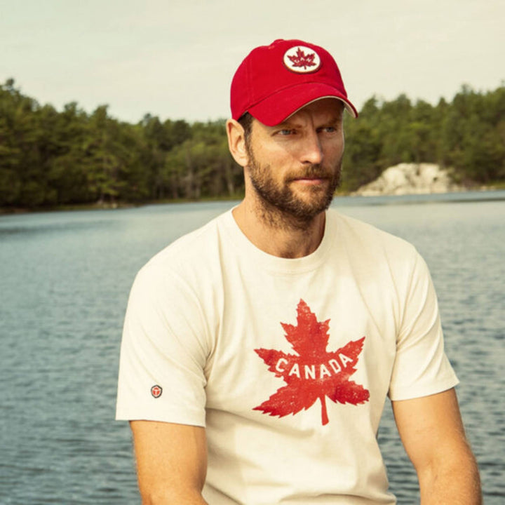 Homme portant un T-shirt heritage canadiens blanc et une casquette par Red Canoe