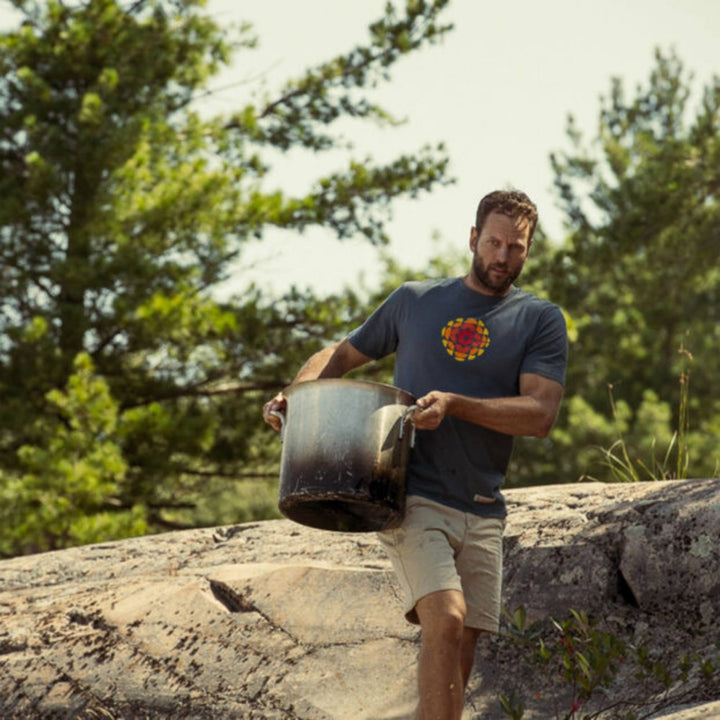 Homme portant un T-shirt CBC Radio canada bleu avec une chaudière dans les mains
