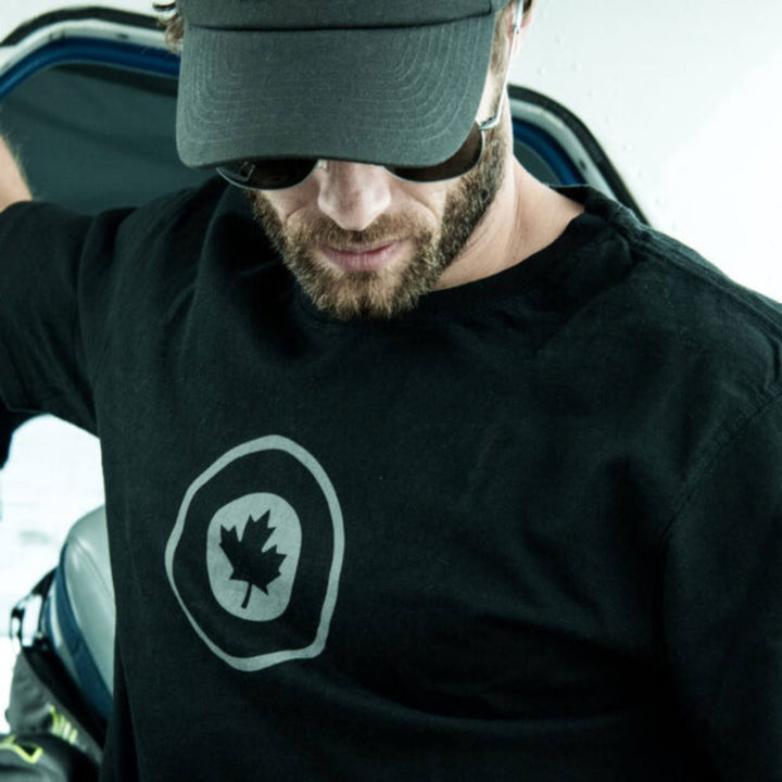 Homme portant une casquette et un T-shirt RCAF noir pour homme par Red Canoe