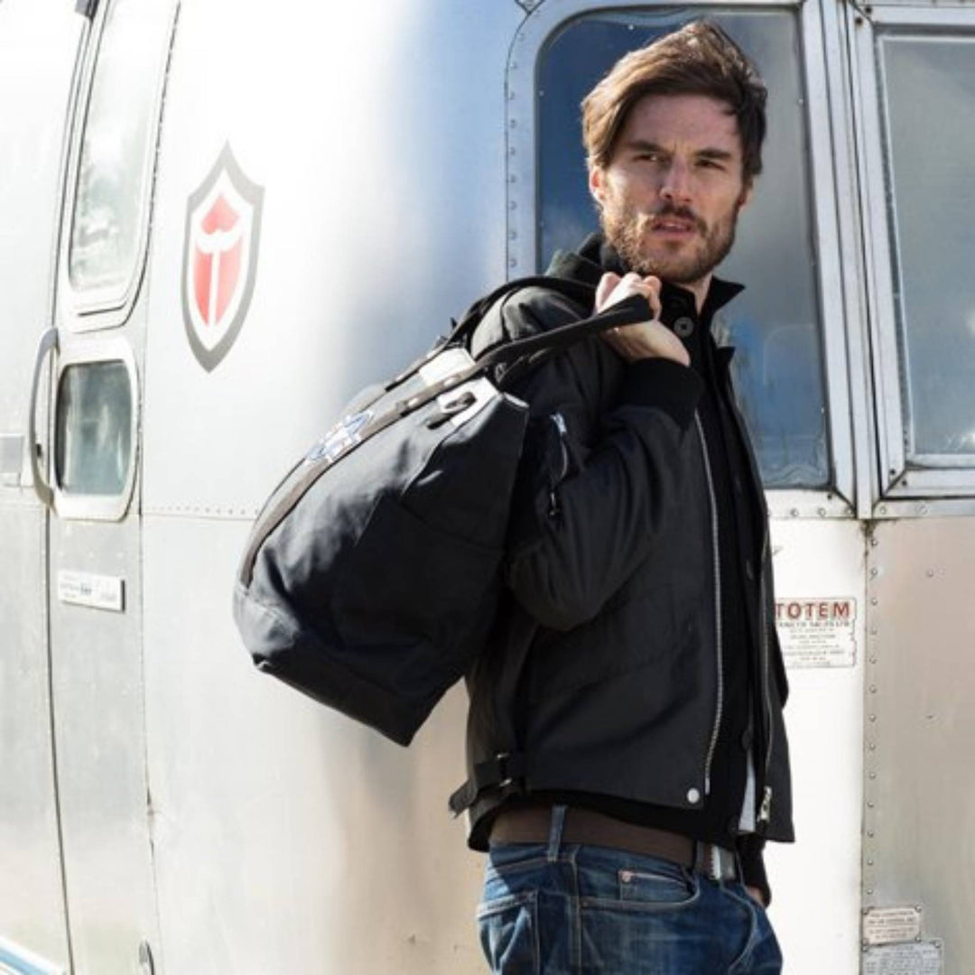 Mannequin homme portant une Veste de vol charbon avec un sac par Red Canoe
