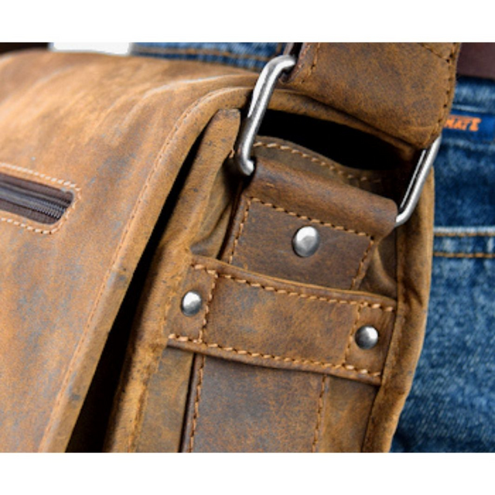 Détails bandouliere d'un sac bandouliere a rabat en cuir de bison vue de coté