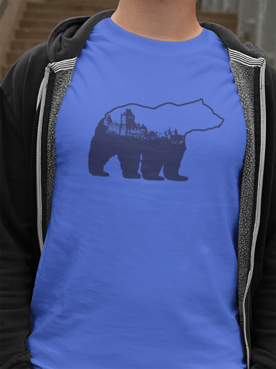 Mannequin portant une veste à capuchon grise par dessus un tshirt bleu avec un motif d'un ours avec la ville de Québec