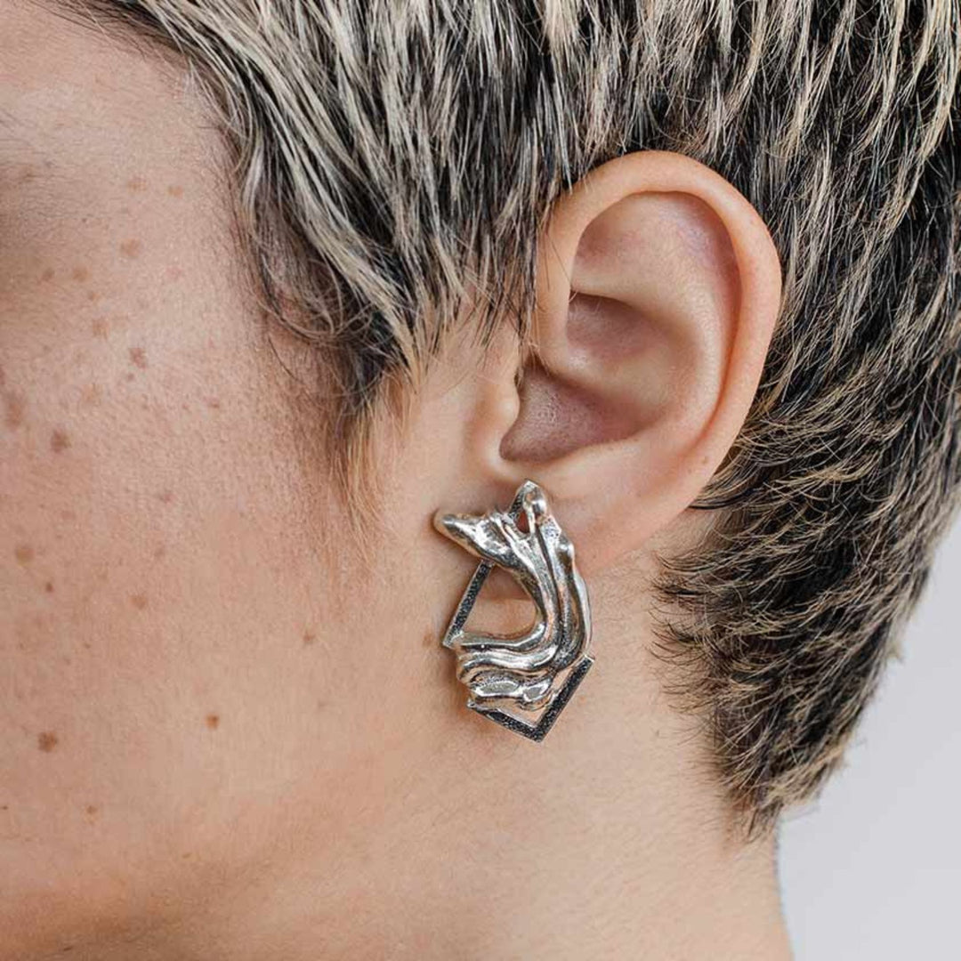 Femme portant des Boucles d'oreilles Anne-Marie Chagnon Pada en forme abstraite en étain