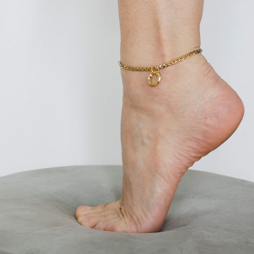 Pieds avec un Bracelet pour chevi;;e Anne-Marie Chagnon Bazae doré avec breloque circulaire