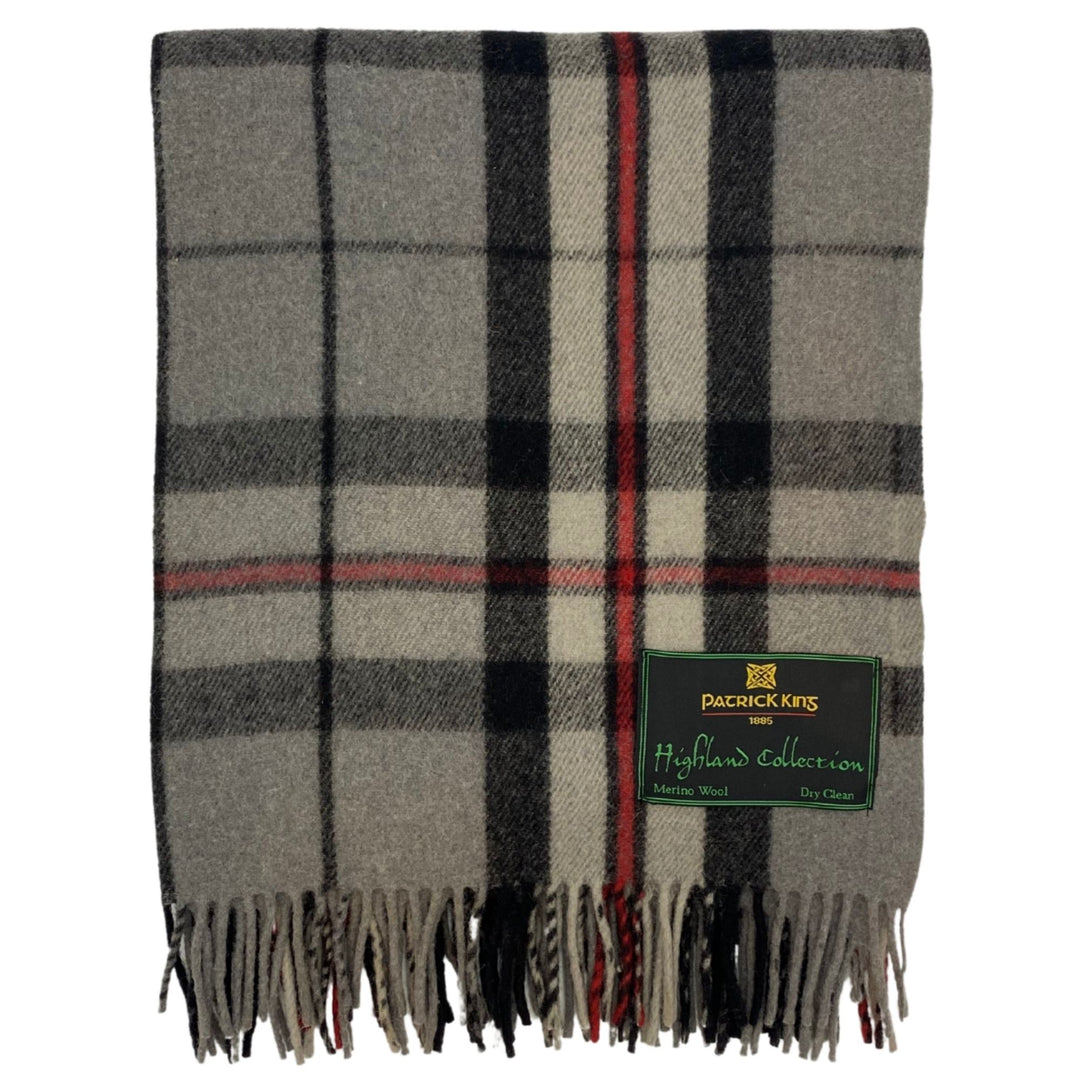 Lourde couverture tartan Highland Collection grise, noire et rouge pliée avec franche dans le bas et une étiquette Patrick King dans le bas droit