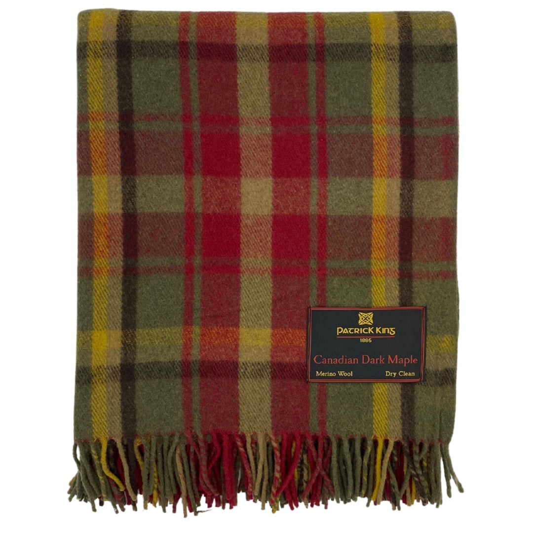 Lourde couverture tartan Canadian Dark Maple pliée verte et rouge avec fines lignes jaunes et une étiquette Patrick King au bas droit et franche dans le bas droit