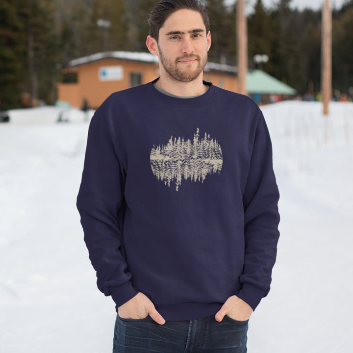 homme à l'extérieur en hiver qui porte un coton ouaté sans capuchon marine avec une illustration d'une forêt qui se reflète sur le lac.