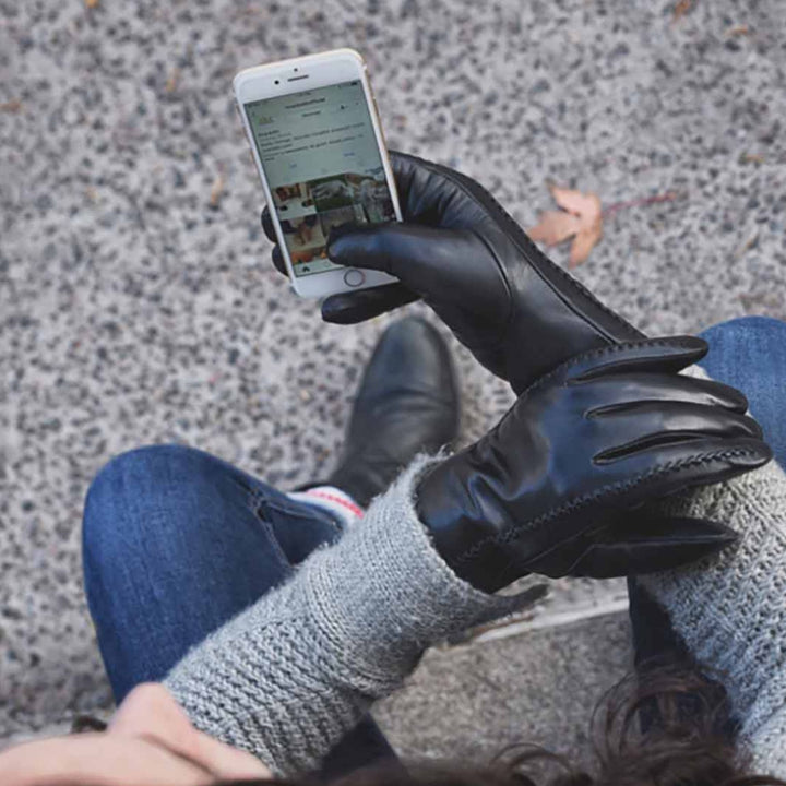 Femme portant des Gants en cuir tactiles sur son cellulaire