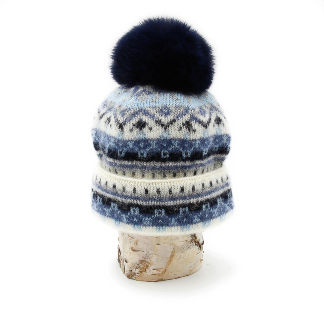Tuque en laine islandaise blanche,bleue marine et bleue pâle avec pompom marine sur une buche