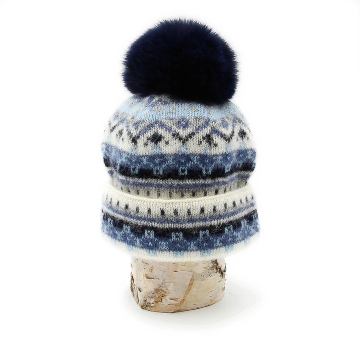 Tuque en laine islandaise blanche,bleue marine et bleue pâle avec pompom marine sur une buche