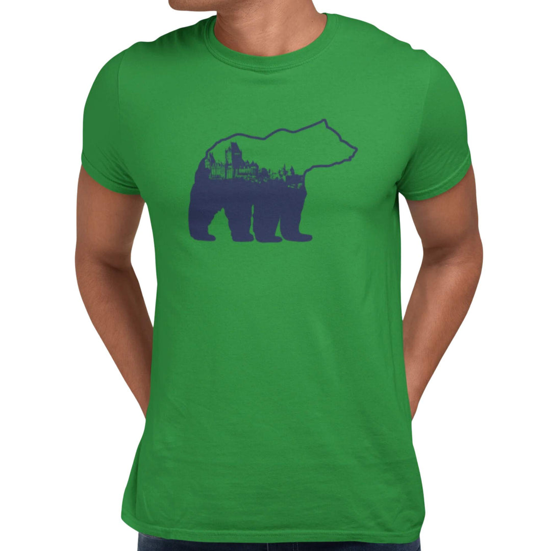 Homme portant un t-shirt KM54 vert pâle avec un design d'ours bleu avec une ville à l'intérieur