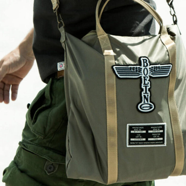 Homme portant un Sac Helmet bag Boeing totem kaki avec poignée par Red Canoe