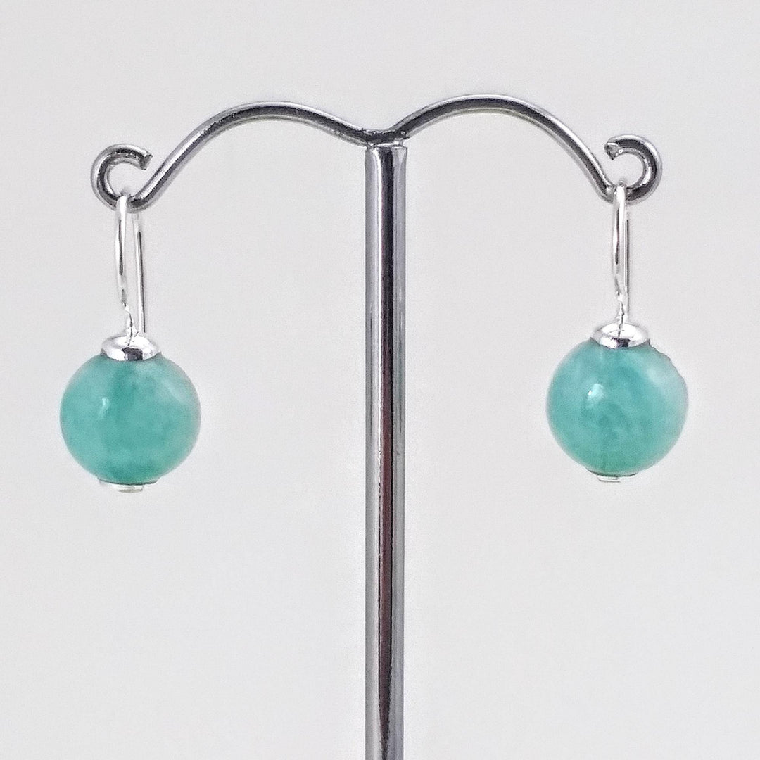 boucles d'oreilles pendantes avec crochet en argent. couleur de la pierre qui est ronde est turquoise-bleue