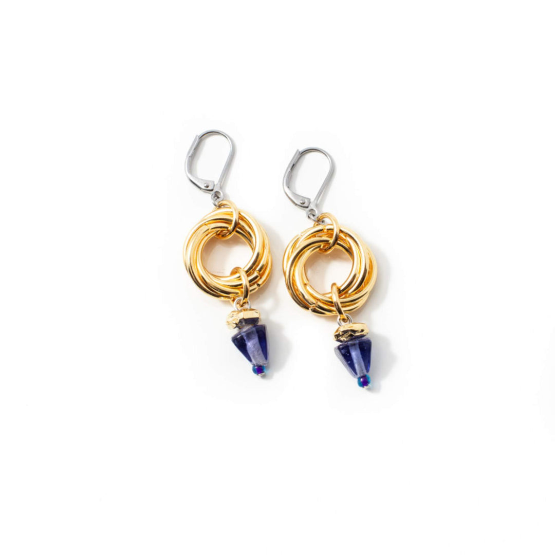 Boucles d'oreilles Anne-Marie Chagnon Jilka avec crochets argentés, anneaux dorés et pierre triangulaire mauve suspendue