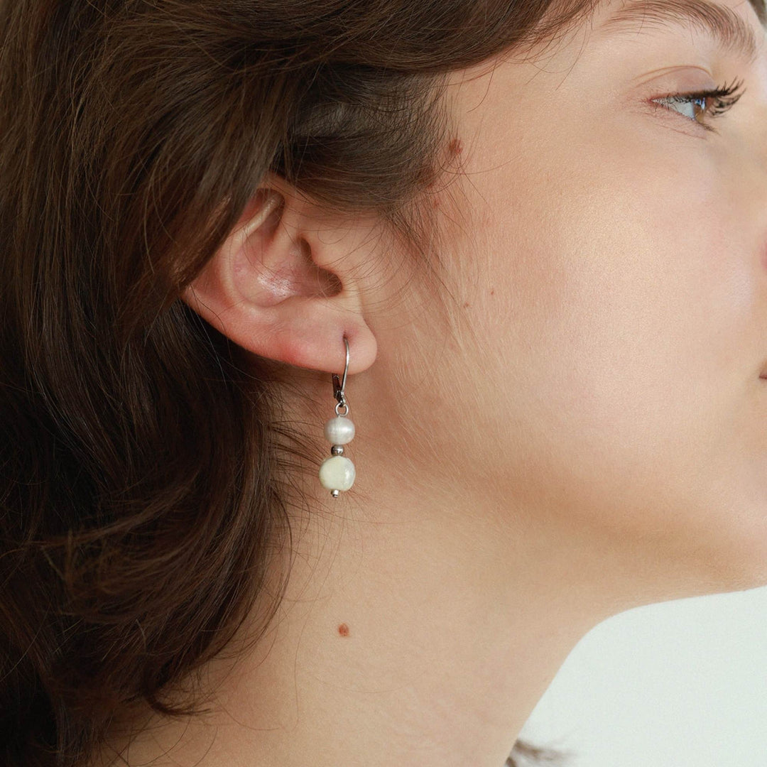 Femme portant une Boucle d'oreilles avec perle et pierre blanche suspendues par Anne-marie Chagnon