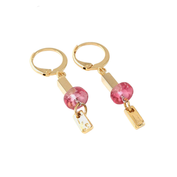 Boucles d'oreilles dorées avec bille rose au milieu par Anne-Marie Chagnon vues de près