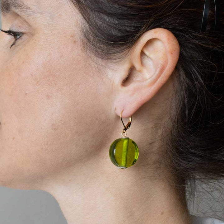 Femme portant des Boucles d'oreilles rondes en verre de couleur verte avec crochet doré par Anne-Marie Chagnon