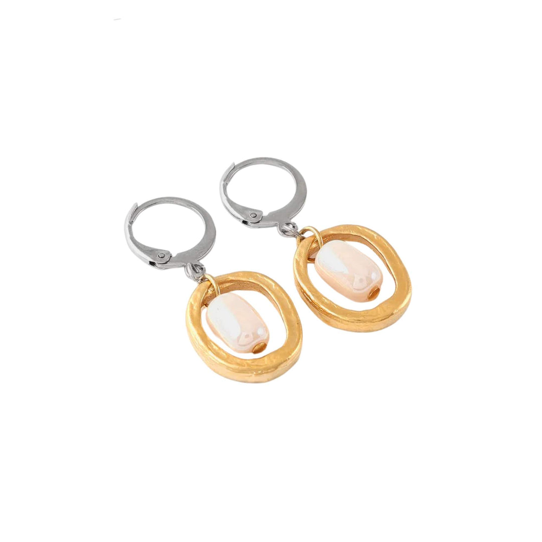 Boucles d'oreilles rondes dorées avec bille de verre rose au milieu par Anne-Marie Chagnon vues de près