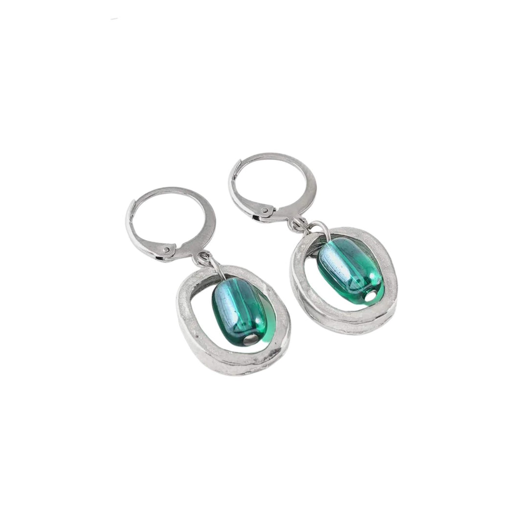 Boucles d'oreilles rondes argentées avec bille de verre turquoise au milieu par Anne-Marie Chagnon vues de près