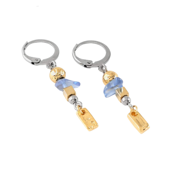 Boucles d'oreilles pendantes argentées et dorées avec pierre bleue par Anne-Marie Chagnon vues de près
