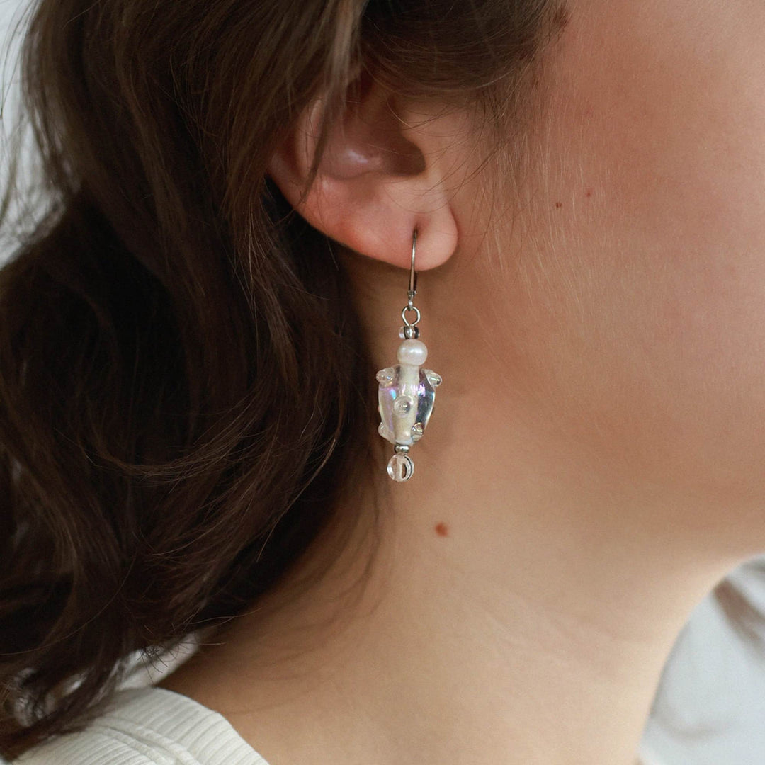 Femme portant une Boucle d'oreilles Fayla transparentes avec perles suspendues par Anne-Marie Chagnon