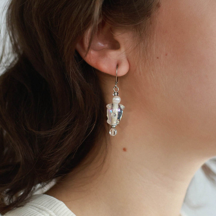 Femme portant une Boucle d'oreilles Fayla transparentes avec perles suspendues par Anne-Marie Chagnon