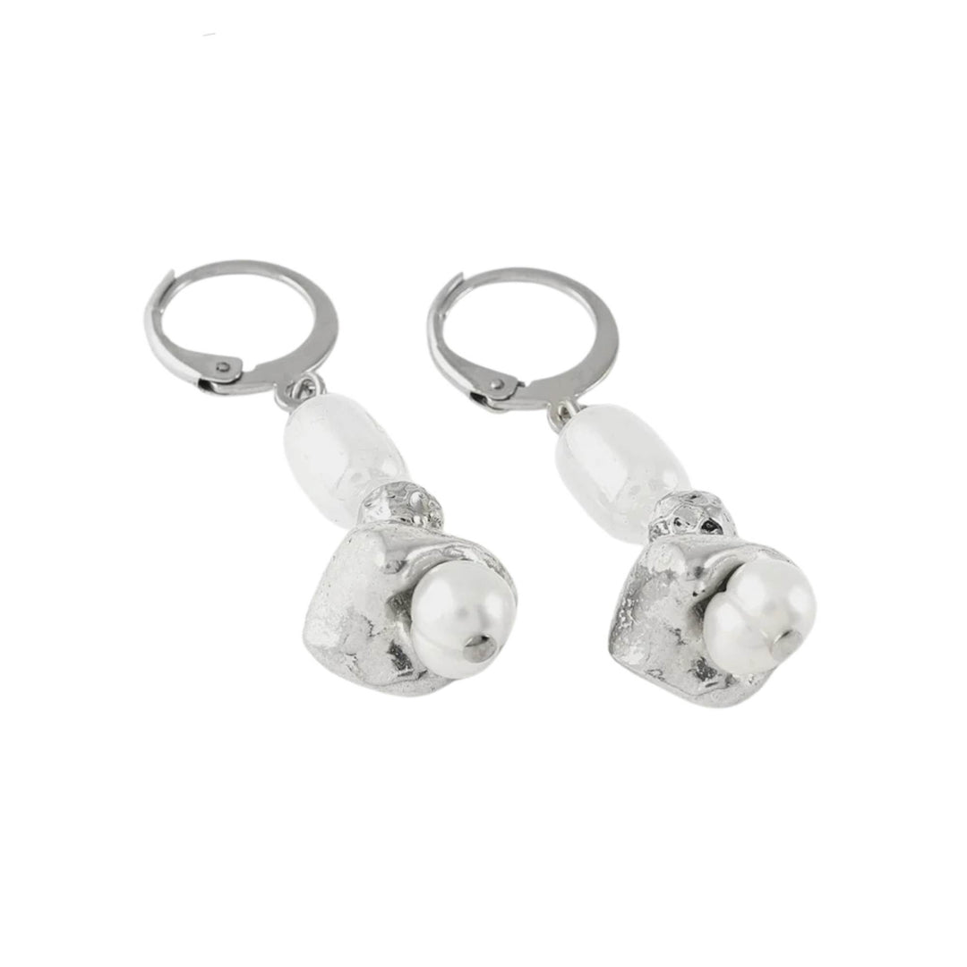 Boucles d'oreilles pendantes argentées  avec perle blanche au centre par Anne-Marie Chagnon vues de près