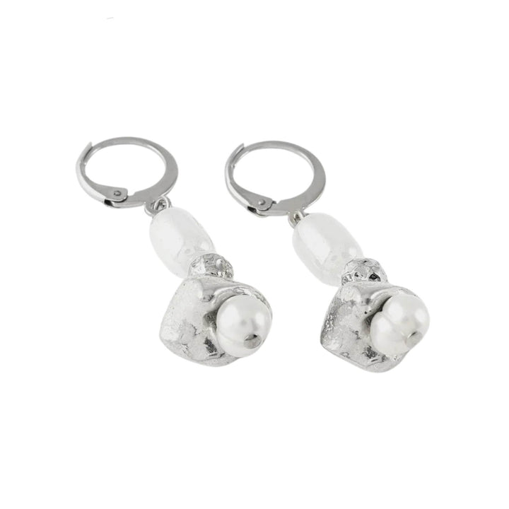 Boucles d'oreilles pendantes argentées  avec perle blanche au centre par Anne-Marie Chagnon vues de près