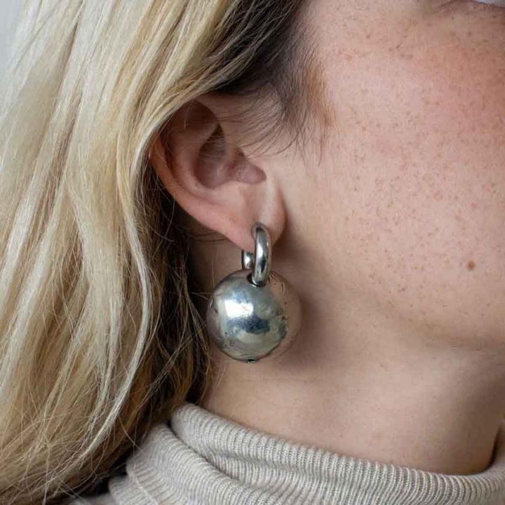 Femme portant des Boucles d'oreilles rondes en étain avec anneau par Anne-Marie Chagnon